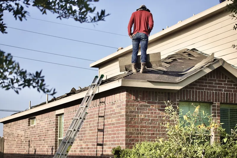Professional roofer working on a residential roof in Buckshutem